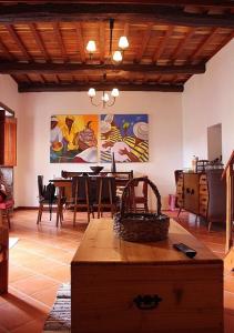 a living room with a table and a dining room at Moradia Rústica Jardim in Caloura
