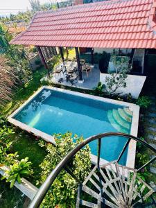a swimming pool in a yard with a red roof at An's House - Đóng trên booking - LH trực tiếp in Phan Thiet