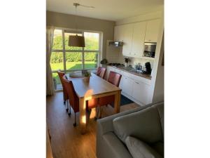 a kitchen and dining room with a table and a couch at Christoffellaan 72 in Brouwershaven