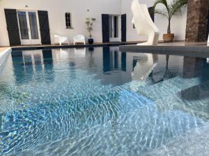 a swimming pool with blue water in a house at Le Patio Bleu in La Crau