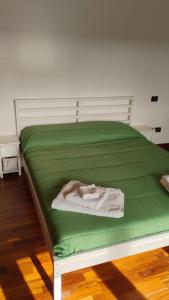a green bed with a blanket on top of it at Maison Laurier in Fiumicino Airport