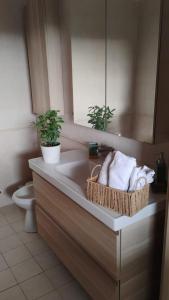 a bathroom with a sink with towels and a toilet at Maison Laurier in Fiumicino Airport