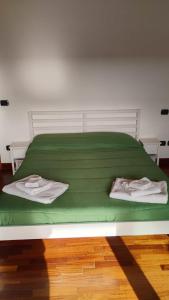 a green bed with two pillows on it in a room at Maison Laurier in Fiumicino Airport