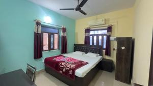 a bedroom with a bed with a red bedspread at Rama Guest House in Bodh Gaya +39 photos