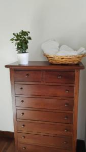 a wooden dresser with a basket on top of it at Maison Laurier in Fiumicino Airport