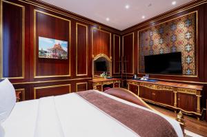 a bedroom with a bed and a flat screen tv at V V Hotel Battambang in Battambang