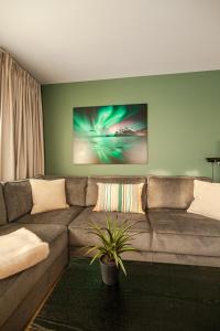 a living room with a brown couch with a plant at Lofoten Premium Suites in Leknes