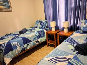 a bedroom with two beds and two lamps on tables at Just Property Zululand in Richards Bay +12 photos