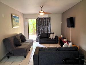 a living room with two couches and a tv at Just Property Zululand in Richards Bay