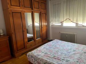 a bedroom with a wooden cabinet and a bed at ELENA Center Apartment in Timişoara