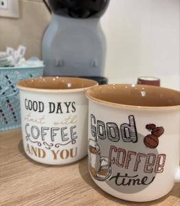two coffee cups with the words good days and a good coffee and you at LeRoccheRoom in Monreale