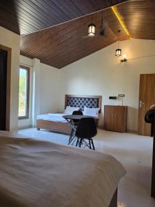 a bedroom with a bed and a desk and a table at The Jungle Castle Resort in Rāmnagar