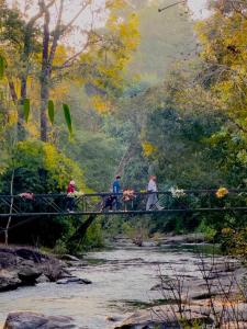 a painting of people crossing a bridge over a river at Ban Kham Kee Homestay in Chiang Mai