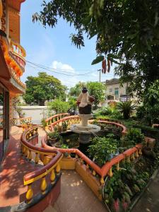 a person standing in a fountain in a garden at Monalisa Lodge in Vishnupur