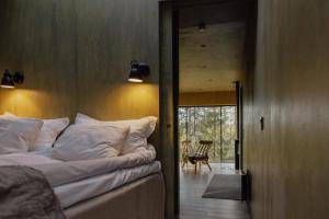 a bedroom with a bed and a door leading to a patio at Trakt Forest Hotel Skogssviter in Holsbybrunn
