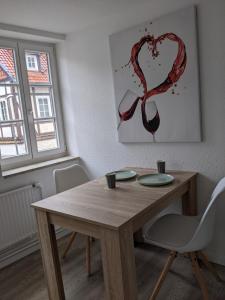 a wooden table with two chairs and a heart painting at Bad Salzdetfurth Gästewohnungen in Bad Salzdetfurth +8 photos