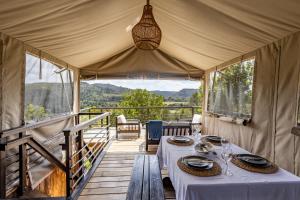 a tent with a table on a wooden deck at Howberry Hills in Plettenberg Bay