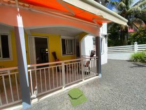 a porch of a house with an orange roof at Mon petit coin de paradis in Morne-à-lʼEau