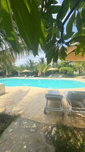 a picnic table and a bench next to a swimming pool at Villa Rebecca 1 at Paparemo Village in Watamu +18 photos