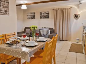 a dining room and living room with a table and chairs at Dairy Cottage in Marros