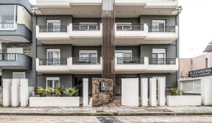 an apartment building with white columns on a street at ALEXANDRA Boutique Residence Seaside in Alexandroupoli