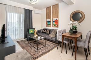 a living room with a couch and a table at ALEXANDRA Boutique Residence Seaside in Alexandroupoli