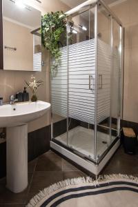 a bathroom with a glass shower and a sink at ALEXANDRA Boutique Residence Seaside in Alexandroupoli +19 photos