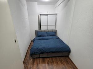 a small bed in a small room with a mirror at Eloi Apartment in Gjakove