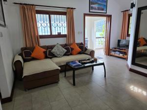 a living room with a couch and a table at The Drake Seaside Apartment in Bel Ombre