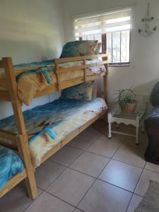 a bedroom with two bunk beds in a room at Michelle's Cottage by the Sea in Port Shepstone