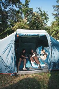 a group of people sitting in a tent at Beer Base-Camp Oktoberfest camping with free welcome beer and traditional dirndl-lederhosen shop in Munich