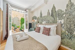 a bedroom with a bed and a mural of trees at La Maison Kléber - Luxury apartments, Eiffel Tower - Champs-Elysées in Paris