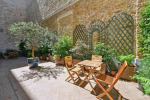 a patio with a table and chairs and potted plants at La Maison Kléber - Luxury apartments, Eiffel Tower - Champs-Elysées in Paris
