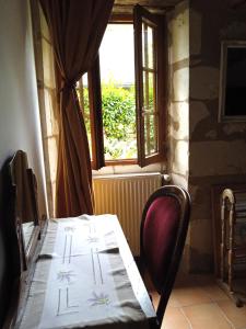 a table and a chair in a room with a window at La Closerie in Saint-Philbert-du-Peuple
