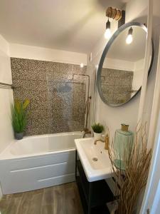 a bathroom with a tub and a sink and a mirror at Loft2 Apartman X ker in Budapest