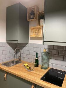 a kitchen counter with a sink and a bottle of wine at Loft2 Apartman X ker in Budapest +12 photos