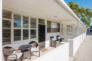 a patio with chairs and a table on a house at Palm Beach Villas by Rockingham Apartments in Rockingham
