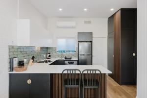 a kitchen with a white counter and black cabinets at Palm Beach Villas by Rockingham Apartments in Rockingham