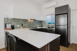 a kitchen with a white counter and a black refrigerator at Palm Beach Villas by Rockingham Apartments in Rockingham +7 photos