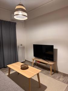 a living room with a flat screen tv and a table at Psani 50m2 apartment in Nafpaktos