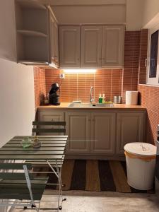 a kitchen with brown cabinets and a sink and a table at Psani 50m2 apartment in Nafpaktos