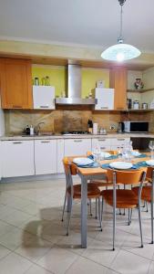a kitchen with a table and chairs in a kitchen at The Happy Goat Apartment in Germignaga