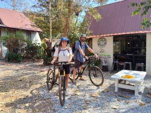 a man and a woman standing with their bikes at Village Homestay in Udon Thani