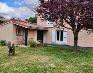 a dog standing in a yard in front of a house at Appartement Cozy in Le Monteil