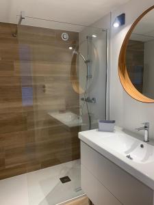 a bathroom with a glass shower and a sink at Appartement Cozy in Le Monteil