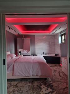 a bedroom with a large bed with red lighting at ApuLux Apartments in Alba Iulia
