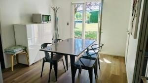 a dining room table with two chairs and a microwave at Appartement Cozy in Le Monteil