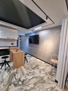 a kitchen with a table and a tv on a wall at ApuLux Apartments in Alba Iulia