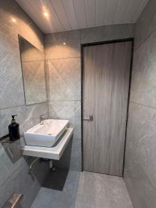 a bathroom with a sink and a wooden door at Hotel Kurla Suites in Mumbai +120 photos