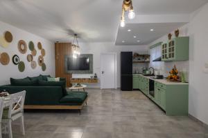 a living room with a green couch and a kitchen at maison de rivière in Afantou